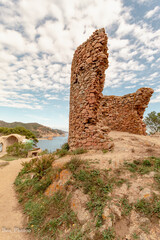 Naklejka premium Ruina romana en lo alto del Castillo de Vela Villa de Tossa de mar con la antigua parroquia de San Vicente al fondo con el tranquilo mar Mediterráneo bajo el precioso cielo con nubes.