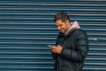 Obraz premium young man in the street with warm clothes and mobile phone