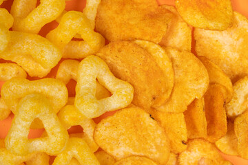 Crispy potato and corn chips, close-up view from above.