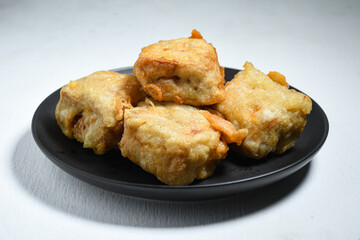 Gorengan or Fried tofu on a black plate. Fried food is one of the favorite snacks in Indonesia and chinna