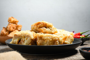 Gorengan or Fried tofu on a black plate. Fried food is one of the favorite snacks in Indonesia and chinna