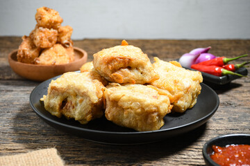 Gorengan or Fried tofu on a black plate. Fried food is one of the favorite snacks in Indonesia and chinna