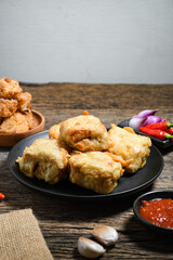 Gorengan or Fried tofu on a black plate. Fried food is one of the favorite snacks in Indonesia and chinna