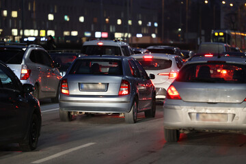 Samochody stoją w mieście w czasie wieczornego szczytu w korku przed świętami zimowymi. - obrazy, fototapety, plakaty