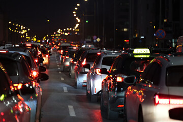 Samochody stoją w mieście w czasie wieczornego szczytu w korku przed świętami zimowymi. - obrazy, fototapety, plakaty