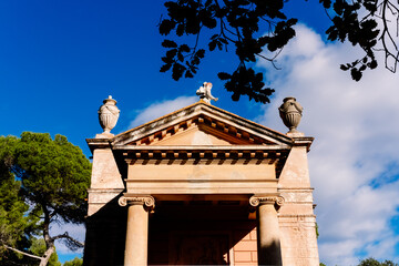 A portico with columns and a triangular pediment on the Greek-style facade of a temple.