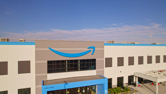 Toronto, Ontario, Canada - September 11, 2022:  Corporate Amazon logo brand name and trademark on the office building and Fulfillment warehouse entrance. Company developed international e-commerce.