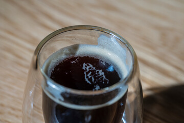 Cup of hot espresso coffee on wooden table, closeup