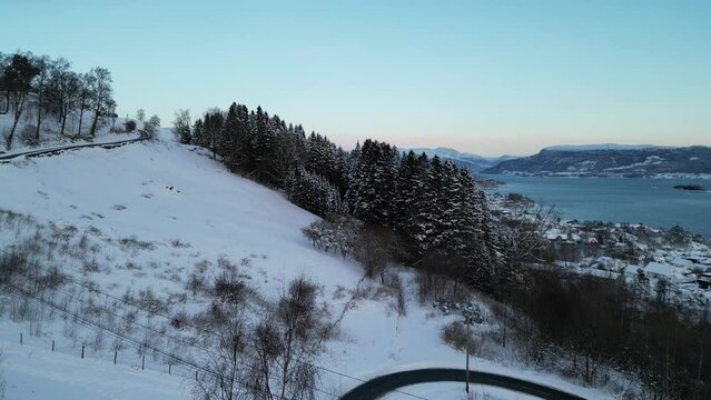Sunset over Norwegian coastal landscape. Winter, mountains and fjord.