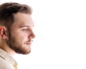 Obraz premium Side-view portrait of young bearded caucasian male isolated on white background