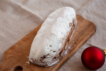 Homemade Christmas Stollen Bread on a rustic wooden board, side view.