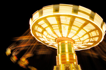 Amusement Rides carousel swing ride spinning lights blurred at night