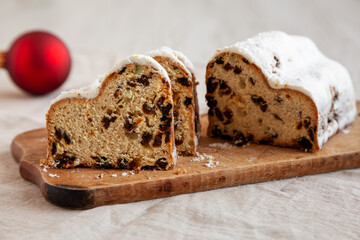 Homemade Christmas Stollen Bread on a rustic wooden board, side view. Close-up.