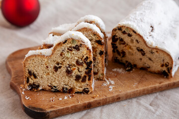 Homemade Christmas Stollen Bread on a rustic wooden board, side view.