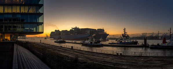 Sunrise in the port of Hamburg with large container ship