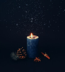 Blue Christmas candle on dark background.. Christmas decor and home decoration for the New...