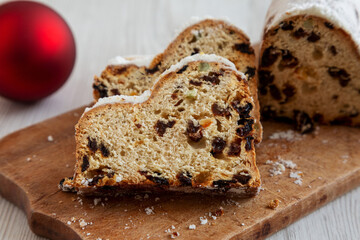 Homemade Christmas Stollen Bread on a rustic wooden board, side view.