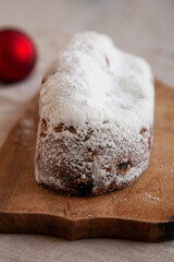 Homemade Christmas Stollen Bread on a rustic wooden board, side view.