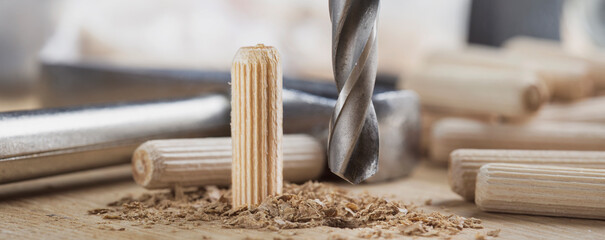 drill bit makes hole in wooden oak board for wooden dowel.