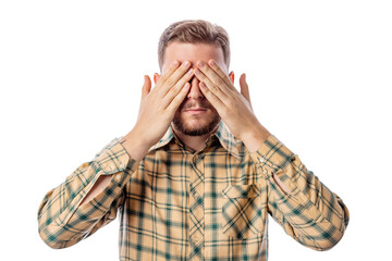 Photo of adult handsome unshaven man closing eyes with hands wearing casual shirt isolated on white background