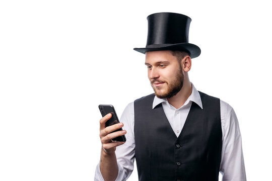 Man in formal cylinder hat, black waist and white shirt holdin smartphone isolated on white background