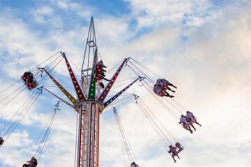 sky swing offride in Carnival funfair. Outdoor, evening, sunset