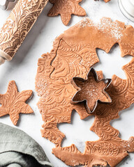 Making Christmas patterned gingerbread process, baking ingredients and dough on white marble. Xmas sweet, winter holidays concept, new year treet. Top view, flat lay