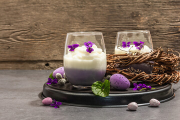 Happy Easter festive composition. Vegan panna cotta dessert with fresh violet flower