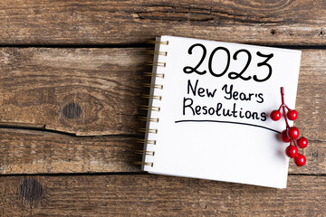 Fototapeta na wymiar New year resolutions 2023 on desk. 2023 resolutions list with notebook, coffee cup, decorations on table. Goals, resolutions, plan, to do list, action concept. New Year 2023 background. Copy space