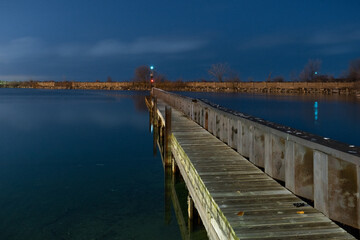 Marina dock at nighttime in front of rock jetty.