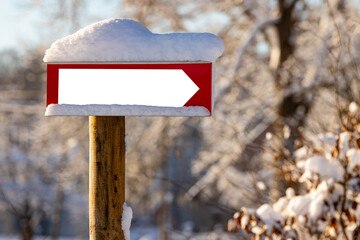 Blank signpost plate covered with fresh snow.