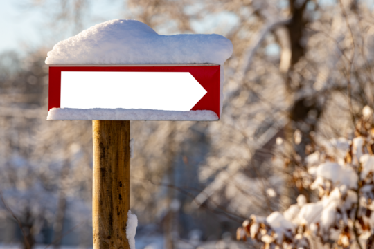 Blank signpost plate covered with fresh snow.