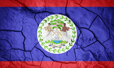 Flag of Belize. Belize symbol. Flag on the background of dry cracked earth. Belize flag with drought concept