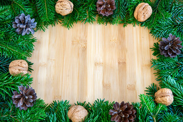 Bożonarodzeniowe tło z gałązkami jodły, szyszkami i orzechami © Monika