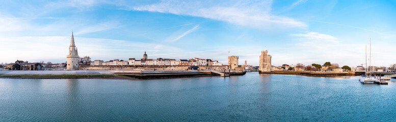 Obraz premium The port of La Rochelle during the blue hour. Panorama of the skyline with its famous towers. banner with copy space