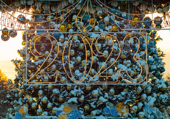 2023 numbers of the new year on the background of the Christmas tree in the sunset light