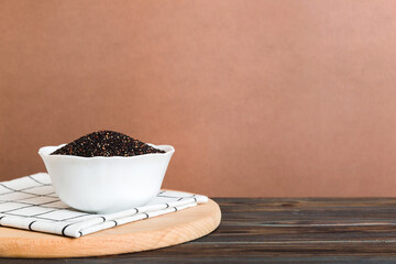quinoa seeds in bowl on colored background. Healthy kinwa in small bowl. Healthy superfood