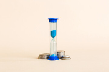 Deadline and time is money concept with hourglass and US coins currency. sand clock time for saving concept