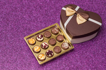Box with delicious chocolate candies and heart shape gift