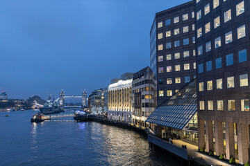LONDON, UK - December 5, 2022: Panorama view of iconic landmark famous illuminated Tower Bridge over Thames river at night dark sky