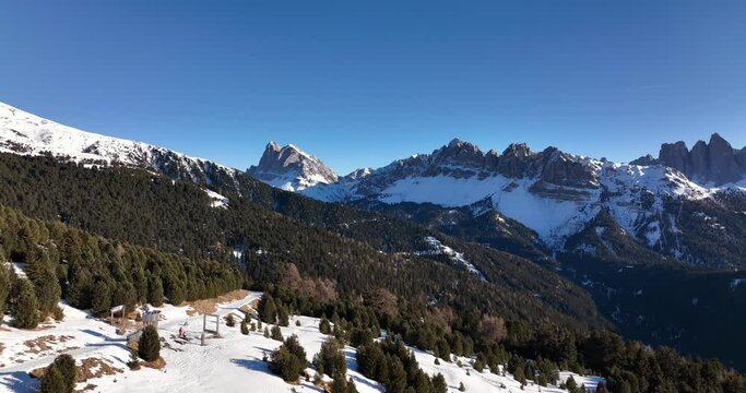 Epic Geisler Mountains in the Dolomites. Aerial Landscape in South Tyrol. Flying above meadows and forests, steep Mountains in the background