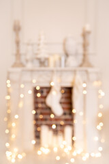 Blurred white fireplace with New Year's socks and a garland. Out of focus. 