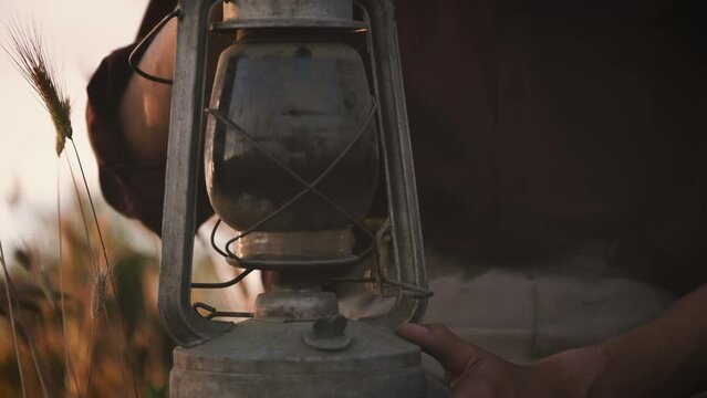 Kerosene retro lamp. Old adult friends wear vintage clothing in ancient times talking and sitting on bench. Relaxing yellow fields and beautiful views village. Retro style, happy sunny day in village