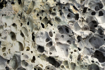 Gray basalt slab background, rough textured, porous, latticed throughout the rock, volcanic slag...