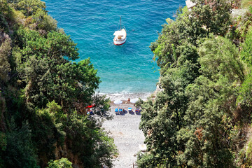 Top view of a narrow intimate bay along the Amalfi Coast with turquoise sea and lush nature in a...