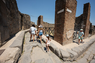 Family tourist walking at Pompeii ancient city, Italy.
