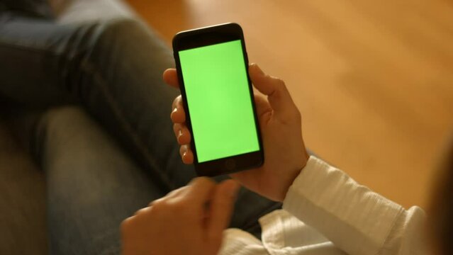 The user holds a smartphone with a green screen and swipes to the left