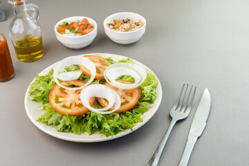 Fresh salad with lettuce, tomato and onion accompanied by farofa and vinaigrette. Typical Brazilian food. Selective focus