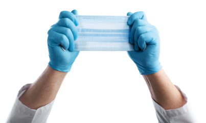 A medic's hand holding face mask over blue textured. Protective respiratory mask