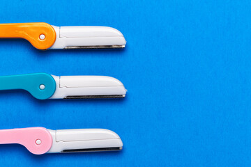 multicolored razor shavers. Colored razors shavers, on a blue background. copy space for text. View from above.